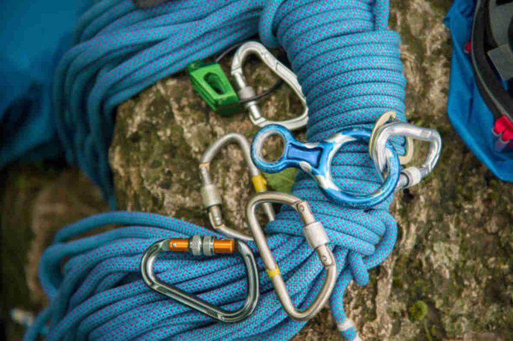 used equipment for climbing where the rope carbines and climbing slippers lie on a rock